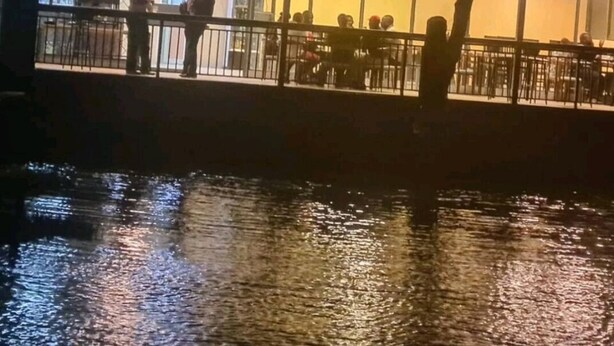 Un edificio con fachada de vidrio y un balcón con vista al agua.