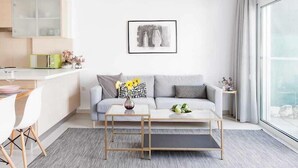 A modern living room with a grey sofa, a coffee table, and a framed picture on the wall. - Adhilli i residence (Rethymno)