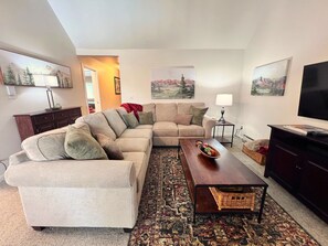 A living room with a beige sectional sofa, a wooden coffee table, and a patterned rug. - Park Place Aspen Condo • Walk to Main St. • Snowflake Lift • Pool+Hot Tubs (Breckenridge)