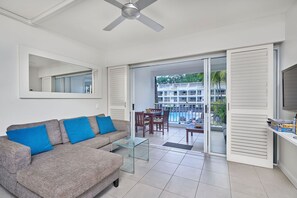 Relax in this stylish living room with a sofa, coffee table, ceiling fan, and large mirror.