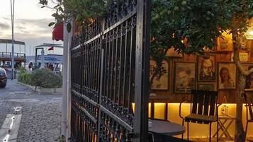 A cobblestone path, a metal fence, and outdoor seating with chairs and tables.
