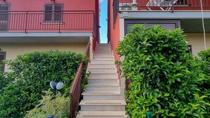 Eine Treppe führt zu einem roten Gebäude mit Balkonen und Wäsche, die an der Luft trocknet.