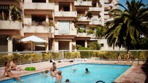 A swimming pool surrounded by a multi-story building with balconies. - Studio in Residence with swimming pool and solarium, 5 minutes from the beach (Roquebrune-Cap-Martin)