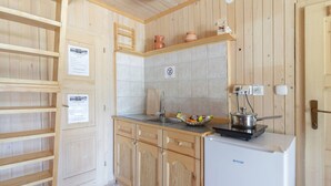 A compact kitchen with wooden cabinets, a sink, a stove, and a refrigerator. - Stunning Views - Chalet Encijan - Velika Planina (Kamnik)