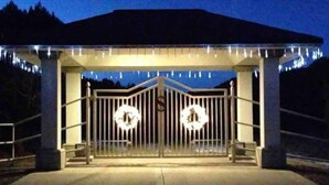 A gated entrance with a decorative archway and two circular wreaths on the gate. - Exquisite Mountain Mansion West Wing (Silver City)