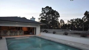 A swimming pool with a covered patio area and outdoor seating. - Exquisite Mountain Mansion West Wing (Silver City)