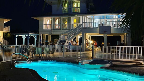 A multi-story hotel with a pool area, including a small boat and a staircase leading to the upper floors. - Luxury Oceanview Pool Eco-friendly Villa Near Key West (Summerland Key)