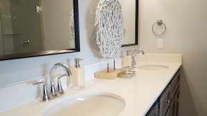 A bathroom with two sinks, a mirror, and a towel rack. - The Cosmopolitan Modern, Cozy, New 3bedroom Home (Yukon)