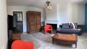 Una sala de estar con chimenea, un sofá, una mesa de centro y un televisor.