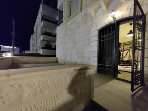 Stunning building exterior with a textured facade, steps, and a covered entrance.
