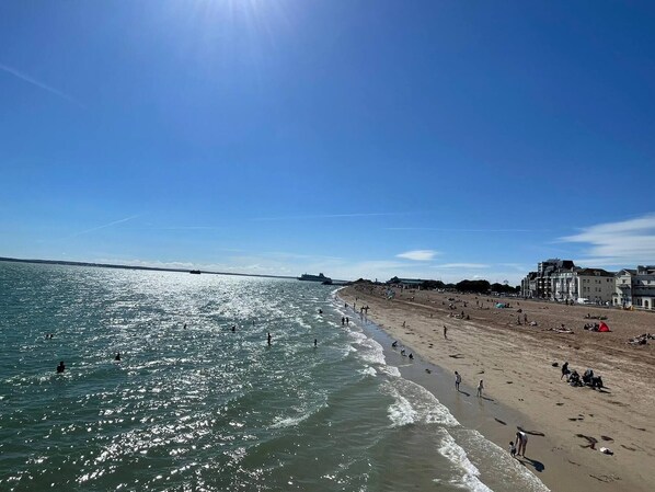 Enjoy the serene beach scene with calm waters and a clear sky.
