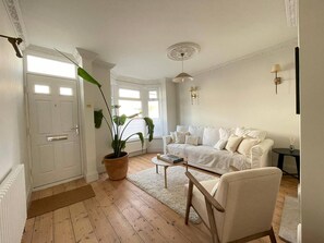 Relax in this stylish living room with a large sofa, coffee table, and potted plant.