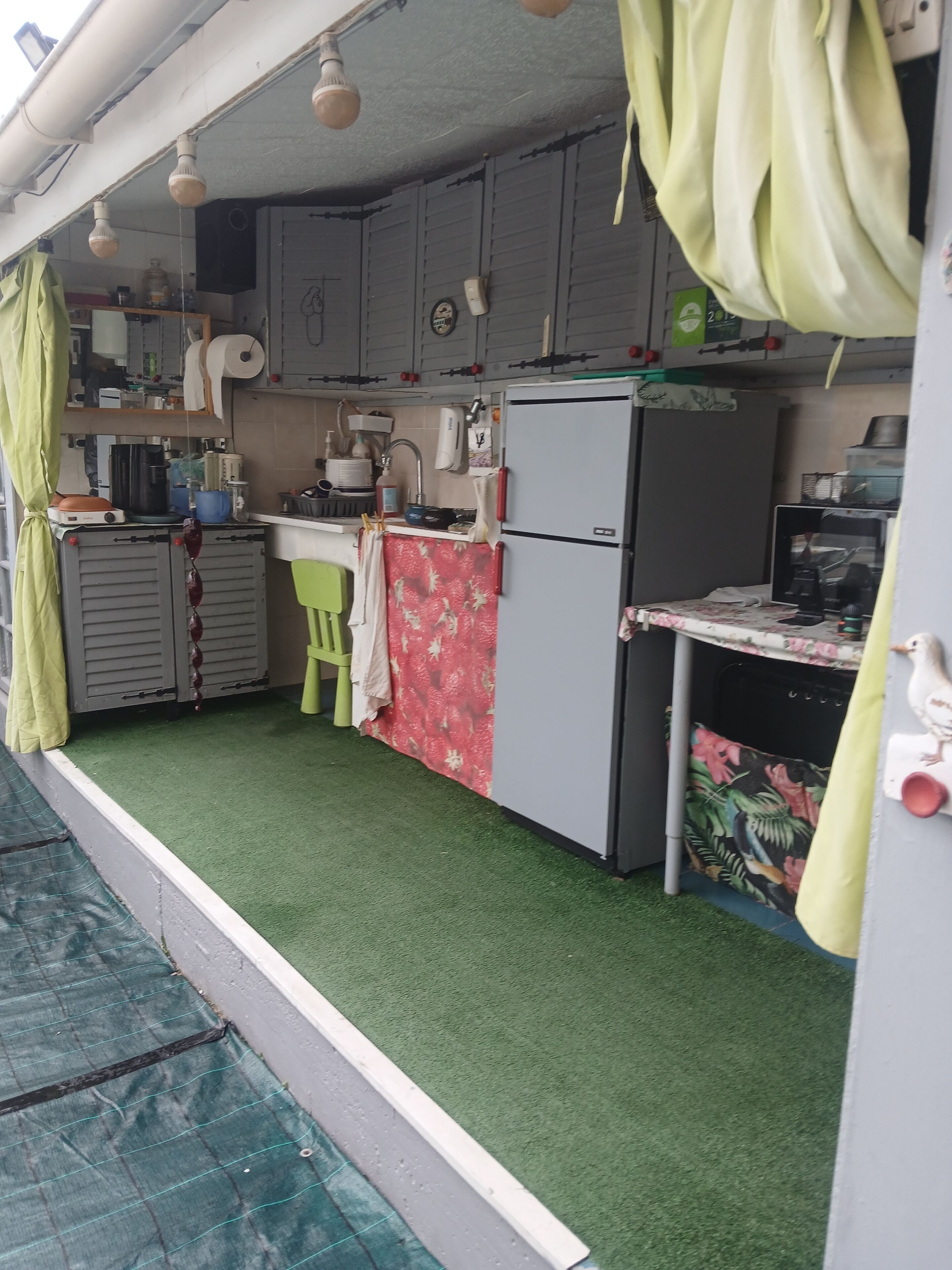A compact kitchen with a refrigerator, sink, and various appliances.