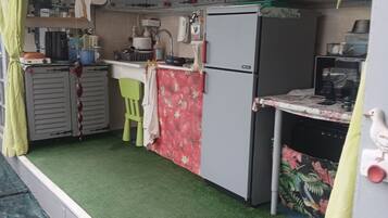 A compact kitchen with a refrigerator, sink, and various appliances.