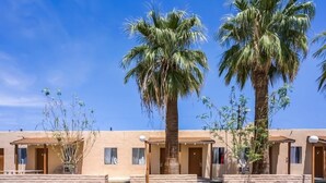 A row of single-story buildings with palm trees in front. - OYO Hotel Yuma AZ - I-8/us-95 (Yuma)