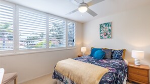 A bedroom with a bed, two bedside tables, a ceiling fan, and a window with blinds. - Ocean Shores, 5 27 Weatherly Close - waterfront unit with views to Shoal Bay and wifi (Nelson Bay)