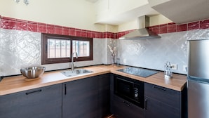 A modern kitchen with dark cabinets, a stainless steel sink, and a built-in dishwasher.