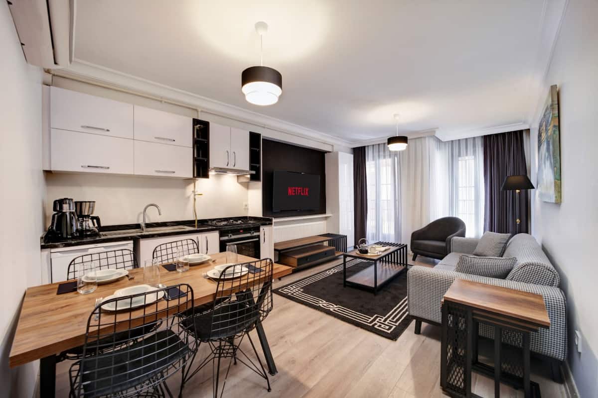 Suite Deluxe | Coin séjour | TV connectée de 130 pouces avec chaînes par satellite, télévision