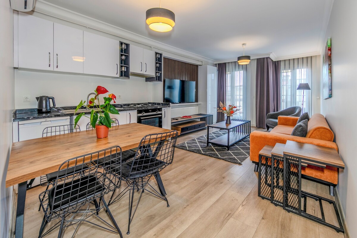 A modern apartment with a kitchen, dining area, and living room.