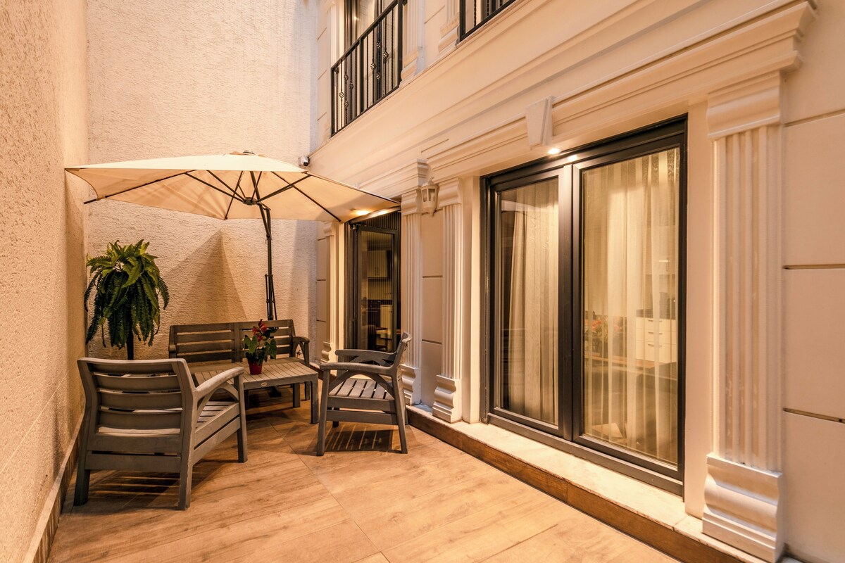 An outdoor seating area with a table, chairs, and a large umbrella.