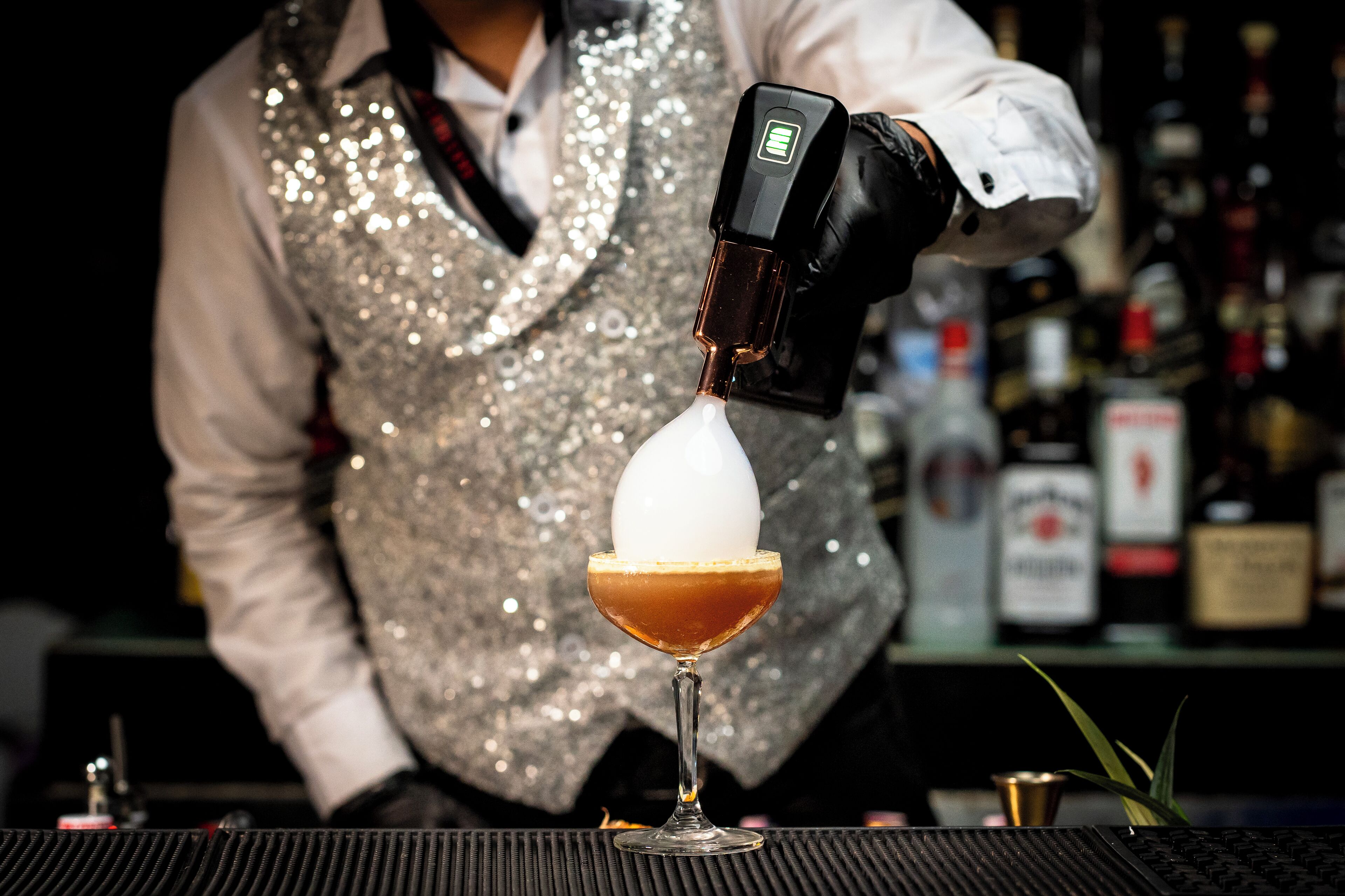 Un barman verse une boisson dans un verre.