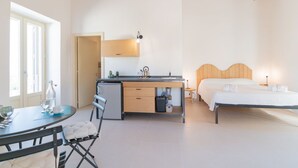 Et moderne soveværelse med en træseng, et skrivebord med stol, og et lille bord med tilhørende stol.