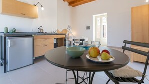 Et moderne køkken med spisebord, køleskab og bænk.