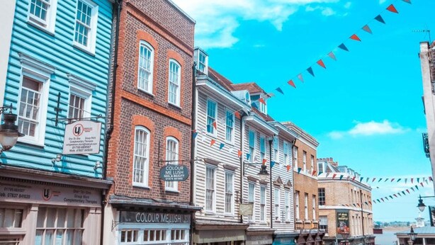 A row of historic buildings with a clear blue sky and bunting flags. - Beautiful and Modern House in Gravesend (Gravesend)