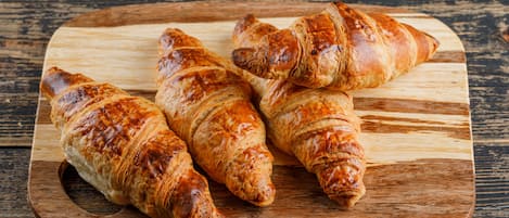 Tres croissants sobre una tabla de madera.