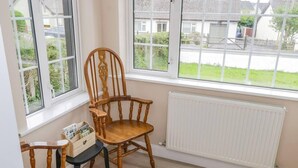 Ein Zimmer mit einem Holzbstuhl, einem kleinen Tisch und einer Heizung.