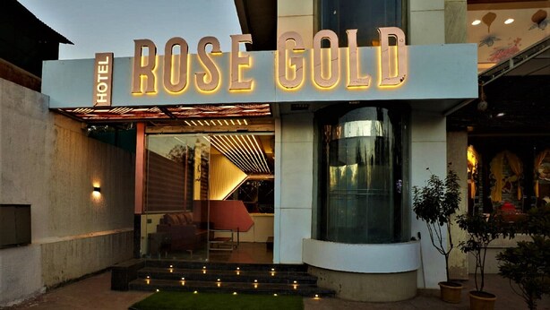 L’extérieur de l’hôtel Rose Gold se distingue par sa façade moderne, son entrée en verre et son panneau lumineux.