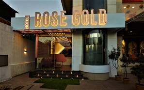 The exterior of the Rose Gold Hotel with a modern facade, a glass entrance, and a well-lit sign. - Hotel Rose Gold (Ahmednagar)