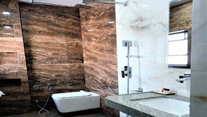 Une salle de bain moderne avec un grand miroir, une baignoire et une douche.