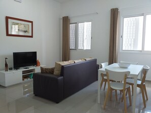 Leilighet – deluxe, 2 soverom, kjøkken, ved stranden | Oppholdsområde | TV og bøker