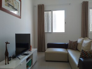 Leilighet – deluxe, 2 soverom, kjøkken, ved stranden | Oppholdsområde | TV og bøker