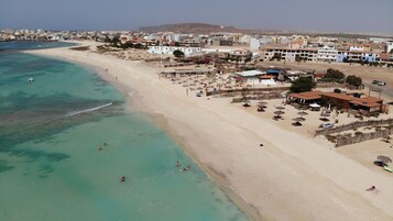 Una playa cerca, arena blanca, toallas de playa, 7 bares en la playa