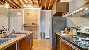 A modern kitchen with wooden cabinets, a stainless steel refrigerator, and a gas stove. - Modern Rustic Charm with City Views (Cincinnati)