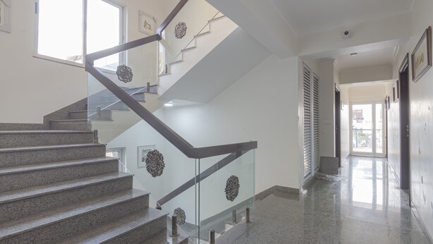 A modern staircase with glass railings and granite steps, leading to an upper floor. - Deluxe Double Room with Balcony (Jaipur)