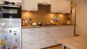 A modern kitchen with a Bosch oven, wooden cabinets, and a stainless steel sink. - 4-star vacation apartment "Sommerberg" incl. Schwarzatal guest card  (Rohrbach)