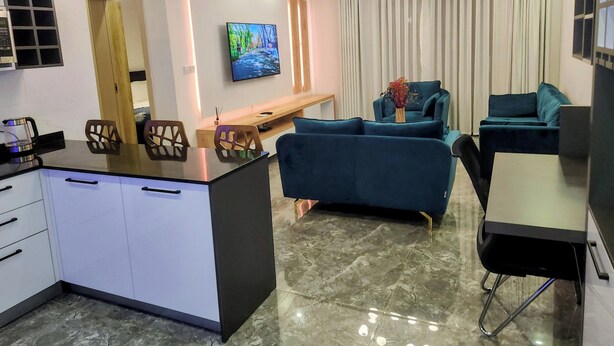 Een moderne woonkamer met een televisie, bank en eethoek.