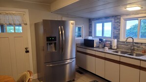 Una cocina moderna con electrodomésticos de acero inoxidable, dispensador de agua integrado y encimera de granito.