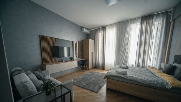 Een moderne slaapkamer met een bed, een bank, een televisie en een bureau.