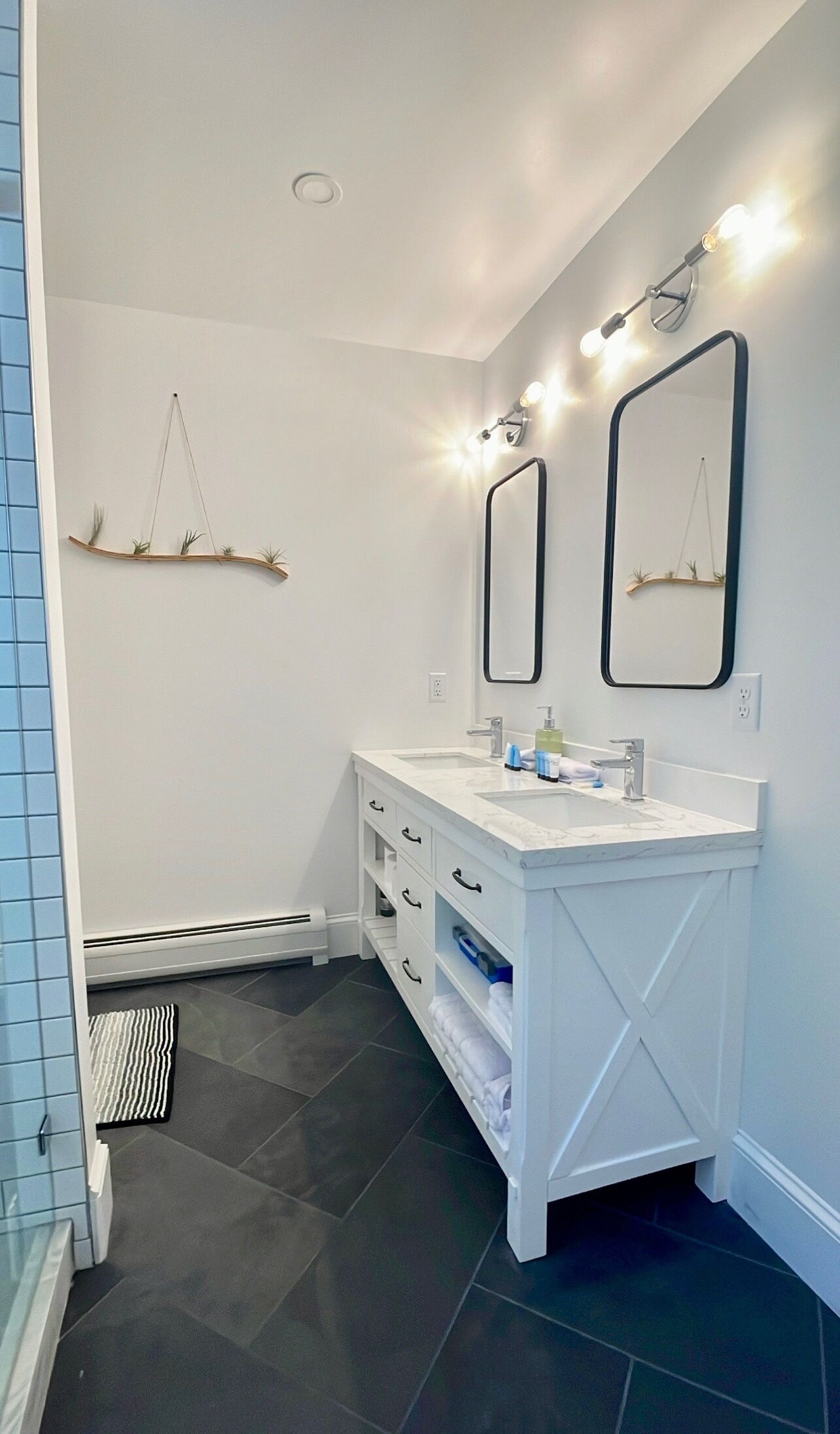 A modern bathroom with two sinks, a vanity, and a mirror.