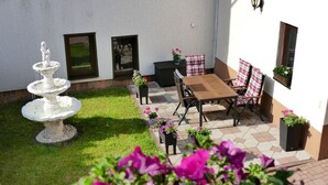 A patio with a stone fountain, outdoor seating, and potted plants. - 4-star vacation apartment "Sorbitztal" incl. guest card Schwarzatal (Rohrbach)