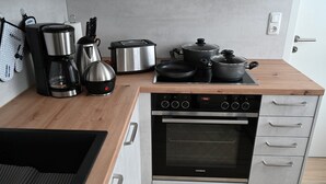 A modern kitchen with a built-in oven, a coffee maker, a toaster, and a kettle. - 4-star vacation apartment "Sorbitztal" incl. guest card Schwarzatal (Rohrbach)