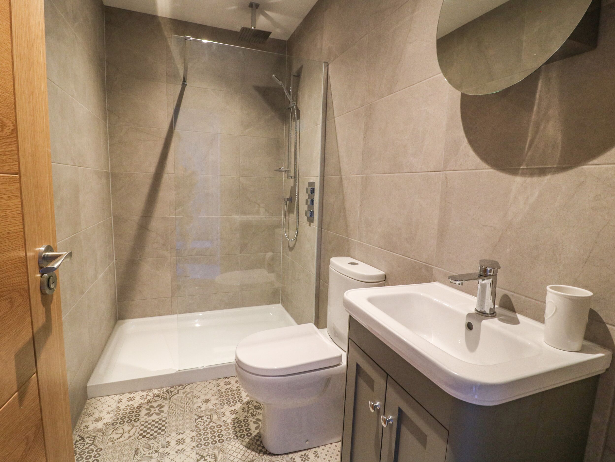 A bathroom with a shower, toilet, and sink.