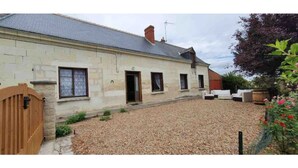 A stone building with a gravel driveway and a wooden gate. - Longère Tourangelle (Bréhémont)