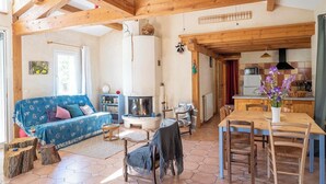Un salon chaleureux avec un canapé bleu, une table à manger en bois et une cheminée.