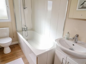 A bathroom with a white toilet, a bathtub, and a sink. - Number 15 (Carnforth)