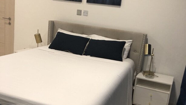 Ein Schlafzimmer mit einem Bett, Nachttischen und zwei an der Wand hängenden Bildern.
